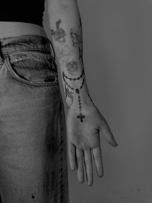 Beautiful black and gray tattoo of a detailed cross and rosary, by talented artist Oliver Soames.