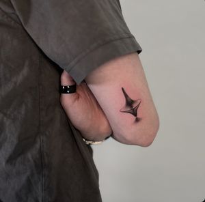 Micro-realistic spinning top totem tattoo in black and gray by Jo Heatley.