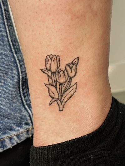 Hand-poked illustrative tulip tattoo in dotwork style by artist Laura.