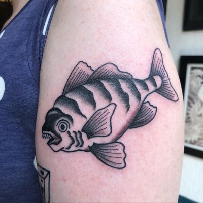 Get a bold and traditional tattoo of a menacing piranha fish by the skilled artist Marc 'Cappi' Caplen. Perfect for those who love unique and eye-catching designs.