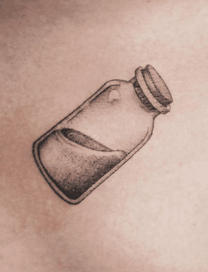 Get bewitched with this black and gray micro realism tattoo of a potion bottle by the talented artist George Francis.