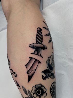 Embrace the strength and bravery with this traditional sword tattoo, expertly done by Marc 'Cappi' Caplen.