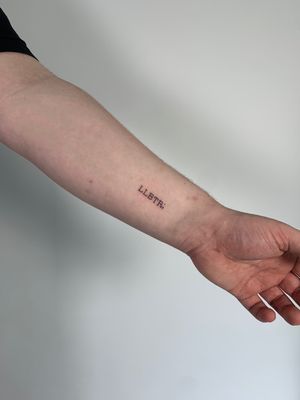 Graceful and intricate small lettering tattoo by Chloe Hartland for a timeless and subtle touch