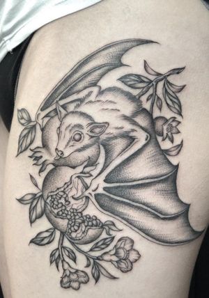 Unique tattoo featuring a bat, tree, flower, fruit, branch, and pomegranate, created by Amandine Canata. Intricate and stunning design.