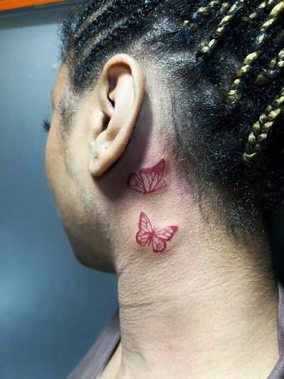 Fine line and illustrative style butterfly tattoo in red ink, by Inna.