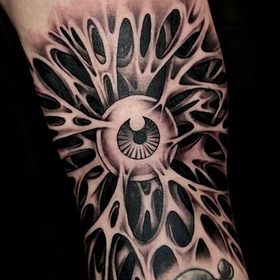 Get captivated by the spooky allure of this black and gray horror-themed eye tattoo, brought to life by the talented artist Ker Kusterbeck.