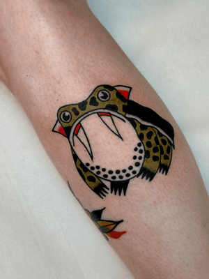 Illustrative traditional tattoo of a cute frog with vampire fangs, by Jakob Isaac.