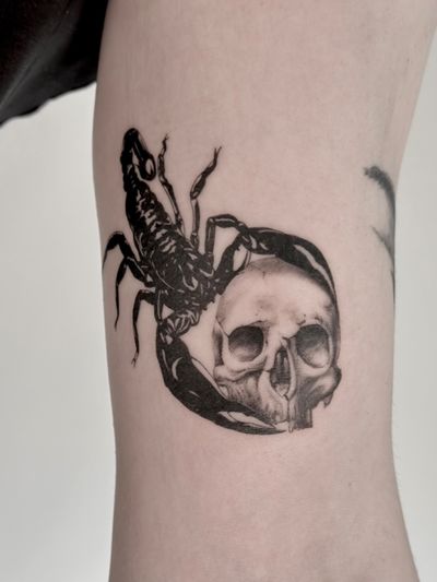 Get inked with a stunning black and gray tattoo featuring a realistic scorpion intertwined with a skull, expertly done by Saka Tattoo.