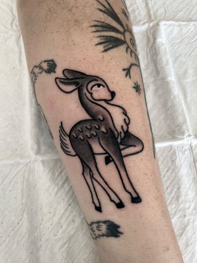 Get inked by renowned artist Marc 'Cappi' Caplen with this stunning traditional style deer and fawn tattoo design.