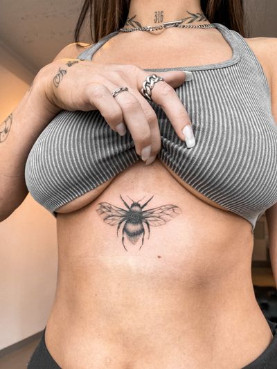 Get a stylish black and gray bee tattoo done by Maria, with intricate fine line details for a unique illustrative look.