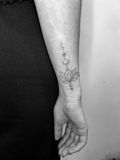 Inna's elegant fine line tattoo of a lotus flower, intricately designed in an ornamental style.