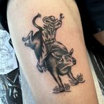 Get your adrenaline pumping with this bold blackwork tattoo of a skeleton cowboy riding a raging bull, done by Kayleigh Cole.