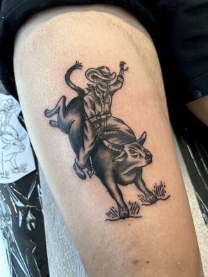 Get your adrenaline pumping with this bold blackwork tattoo of a skeleton cowboy riding a raging bull, done by Kayleigh Cole.