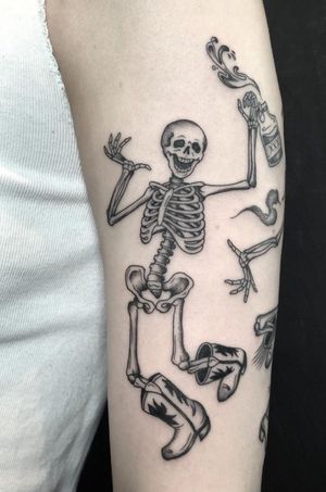 Get in the spooky Western spirit with this illustrative tattoo by Amandine Canata, featuring a dancing cowboy skeleton in boots.