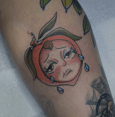 Get this illustrative tattoo of a sad peach, beautifully done by Grown Tattoos. A unique and artistic piece for fruit lovers.