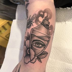 Experience Lawrence Canham's unique blend of black and gray dotwork with traditional and neo-traditional styles in this stunning eye and flower design.