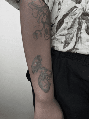 Beautiful black and gray tattoo by Lauren featuring a realistic heart intertwined with a gramophone design