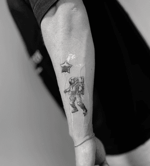 Stunning black & gray tattoo by Vera featuring a lifelike astronaut and metallic balloon design.