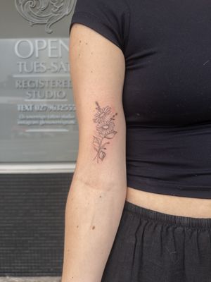 Elegant fine line floral tattoo featuring a delicate flower motif by expert tattoo artist Steffan Eagle.