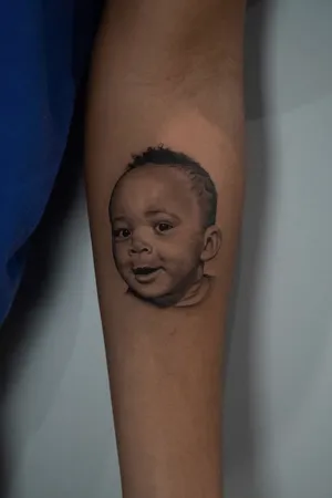 A breathtaking black and gray micro realism portrait of a child, skillfully executed by tattoo artist Kenny Go.