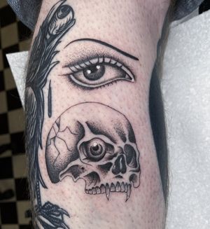 Get a unique illustrative tattoo featuring a skull and eye design by the talented artist Megan Foster. Stand out with this edgy and detailed piece of art.