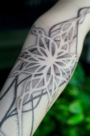 Experience the mesmerizing beauty of intricate dotwork patterns in this flowing, organic design by Mona Noir Tattoo.
