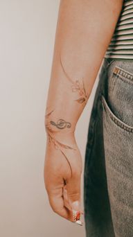 A delicately shaded fine-line floral bracelet wrapped around the forearm, featuring magnolia and nutmeg flowers, drawn freehand to complement the body's lines.