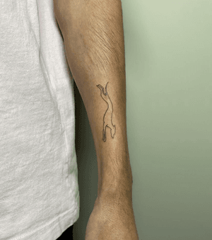 Fine line tattoo of a dog in minimalist outline silhouette by Alfonso Barberio.