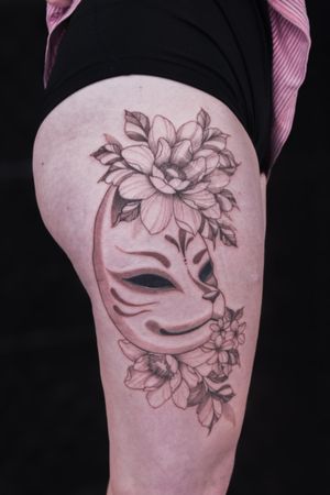 Stunning black and gray fine line tattoo by Steffan Eagle, featuring a beautiful floral design with a mysterious kitsune mask motif.
