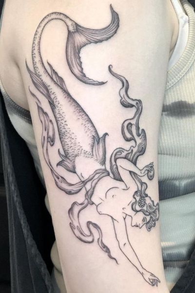 Experience the beauty of the sea with this fine line mermaid tattoo, expertly crafted by Amandine Canata. Perfect for those who love mythical creatures and intricate designs.