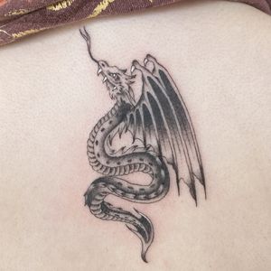 Get mesmerized by Megan Foster's detailed illustrative dragon tattoo. A mystical symbol of power and strength.