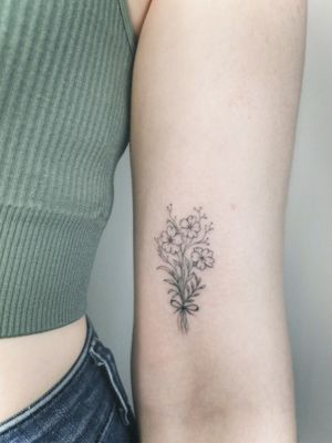 Adorn your skin with a delicate fine line bouquet created by the talented tattoo artist Alina Amberland.