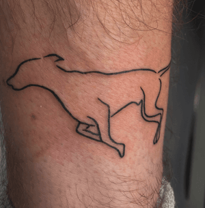 Minimalistic dog outline tattoo with fine line work by Louisa Williams.