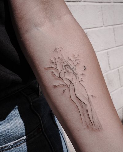 A delicate fine line tattoo featuring a woman surrounded by stars, moons, and a tree, beautifully crafted by Ally.ink.