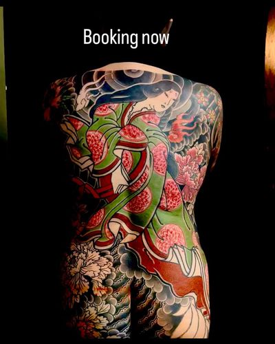 Experience the beauty and mystery of Japanese culture with this intricate tattoo featuring a geisha, fox spirit, and elegant flowers. By renowned artist Ami James.