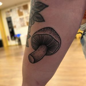Explore the enchanting world of mushrooms with this unique black & gray dotwork design by Lawrence Canham.