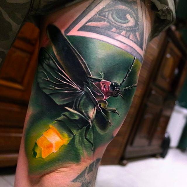 Tattoo of a firefly done on the tricep
