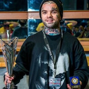 A photo of Kyle "Egg" Williams (IG—egg_ink) holding some of his awards at a tattoo convention. #blackandgrey #dark #KyleEggWilliams #portraiture #realism