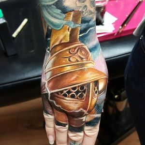 Color realism gladiator helmet hand tattoo by Mat Valles. #realism #colorrealism #MatValles #helmet #gladiator
