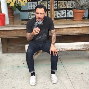 Jason Ochoa sitting outside smoking (IG—jason__ochoa). #GreenpointTattooCo #JasonOchoa #NYCtattooshops