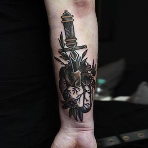 Forearm tattoo of a dagger through an anatomical heart. Solid tattoo work by Ibi Rothe. #IbiRothe #traditionaltattoo #boldtattoos #dagger #heart #anatomicalheart
