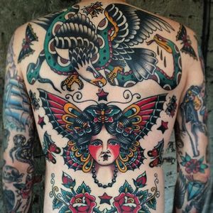 The collage-like nature of this neo-traditional tattoo done by Dan Santoro (Instagram @dan_santoro) challenges the status quo of what defines a backpiece. #bust #butterfly #DanSantoro #eagle #neotraditional #roses #snake #stars