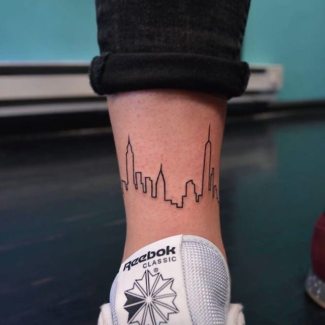 Fine line New York Skyline tattoo on the inner forearm