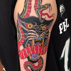 Cat eats snake by Dean Denney #DeanDenney #traditional #color #snake #scales #cat #blackcat #junglecat #panther #fight #tattoooftheday