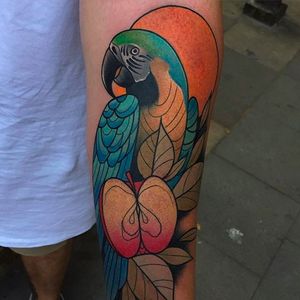 Cool parrot tattoo with an awesome apple to accentuate the cool hue of the bird. Amazing work by Kike Esteras. #KikeEsteras #parrot #apple #coloredtattoo #neotraditional