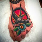 Simple yet stunning swallow bird hand tattoo by Simon Blay. #SimonBlay #TLCtattoo #TraditionalLondonClan #boldtattoos #swallow #blossom