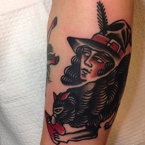 A witch looking lady with a pointy hat and a wolf. Awesome tattoo by Sergey Kartoha. #SergeyKartoha #girltattoo #oldschooltattoo #traditionaltattoo #witch #hat #wolf #heart