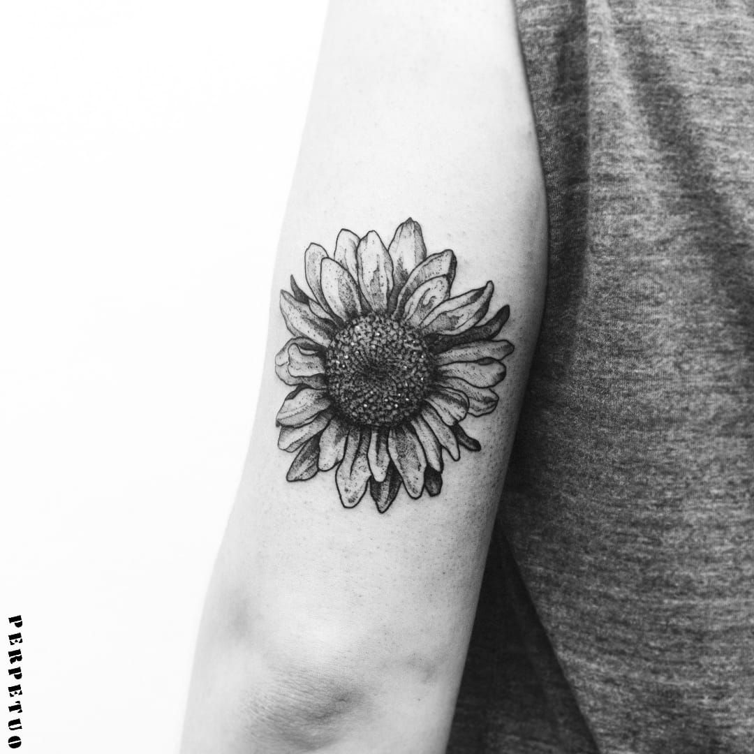 Fine line sunflower tattoo on the tricep