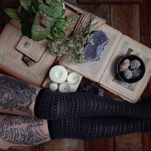 Photo of a tattooed woman next to instruments of witchcraft. #Halloween #magic #tattooedlady #witch #skull