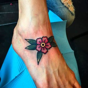 Simple yet solid looking blossom foot tattoo done by Chris Papadakis. #ChrisPapadakis #traditionaltattoo #blossom